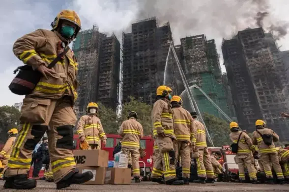 Des pompiers se préparent après qu'un important incendie a ravagé plusieurs immeubles d'appartements du complexe résidentiel Wang Fuk Court à Hong Kong, le 27 novembre 2025
