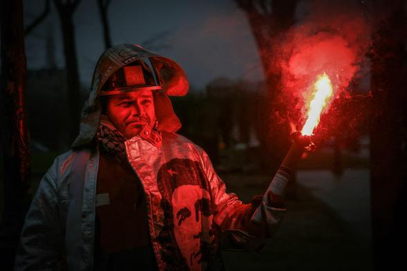 An employee of ArcelorMittal wearing protection gear and holding a torch.