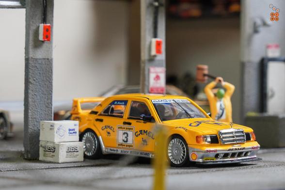 A Mercedes Benz 190E 2.5-1.6 Evolution II, Camel 1990 Yellow Page livery by LMLF in 1:64 scale with 1:64 figure on AREA 164.