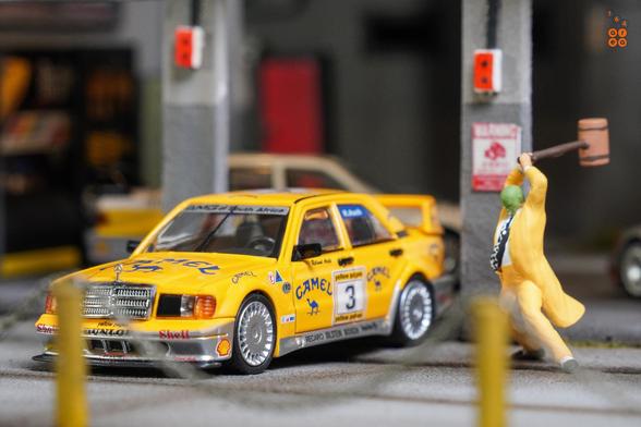 A Mercedes Benz 190E 2.5-1.6 Evolution II, Camel 1990 Yellow Page livery by LMLF in 1:64 scale with 1:64 figure on AREA 164.