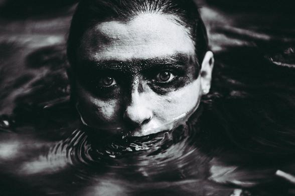 Mujer con línea negra en los ojos en el agua.