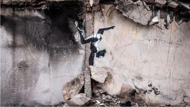 A mural of a gymnast standing on their hands on a ruined wall.

Is it Banksy?

Was it in Gaza?