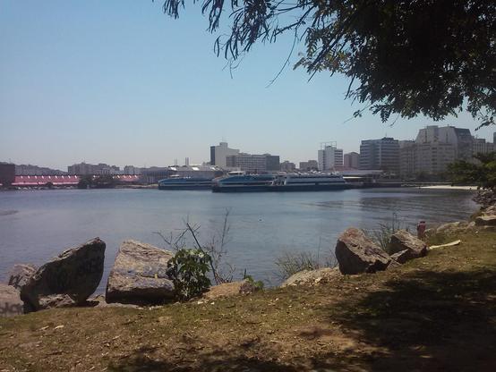 Dois catamarãs atracados, com a baía de Guanabara no primeiro plano e o centro de Niterói ao fundo