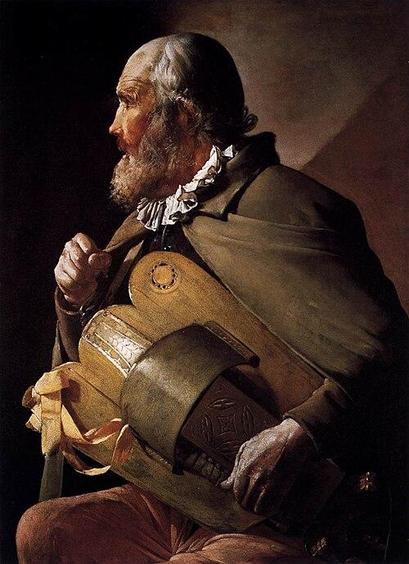 An elderly gentleman with a receding hairline and silver hair covering his ears and curling above his collar is playing a wooden shield-like hurdy-gurdy on his lap. He has a bushy beard. One hand is resting on the bottom part of the instrument while his other hand is grasping a strap holding the instrument against his body. He is wearing a drab-coloured cloak, a small white ruff and brown trousers. There appear to be ribbons tied to the lower left corner of the instrument. He is shown side-on in profile and has ruddy skin while his hands seem gnarled with age. It is hard to tell whether the ingrained dirt shown on his visible skin is a deliberate part of the painting or a sign of the painting's age. Image by Georges de La Tour (1593-1652) from Wikimedia Commons.