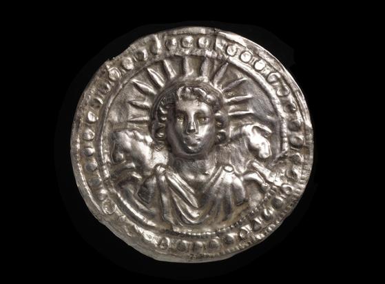 Silver leaf disc dedicated to the sun-god Sol. Sol is crowned with rays, and two horses appear behind his shoulders.