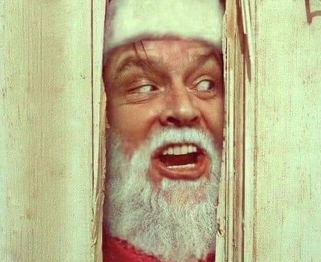 Jack Nicholson scene from The Shining after he took an ax to a door and stuck his face in.  In this picture he is altered to look like Santa Claus.