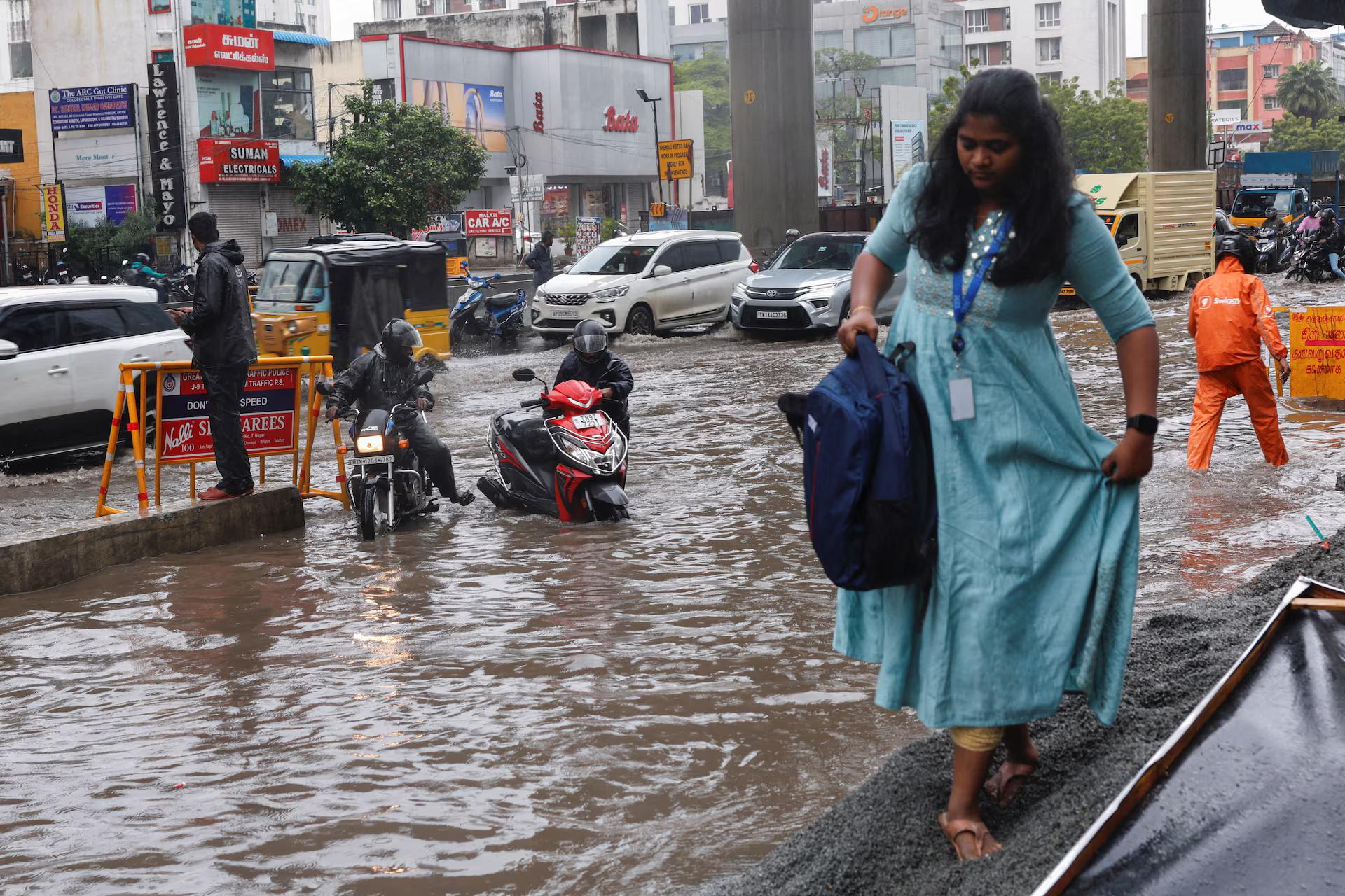 People commute through a water-logged street.