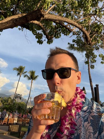 Me at a Luau fiercely sucking at a Mai Tai.