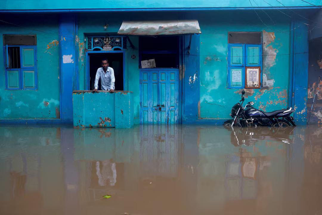 A man looks out from his flooded house as water rises in the aftermath of Cyclone Ditwah in Chennai, India. REUTERS/Priyanshu Singh