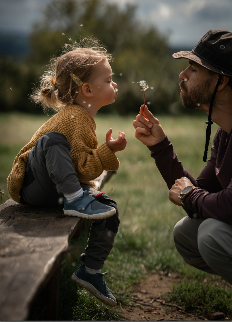 The author with his 3.5-year-old daughter, blowing dandelion seeds.