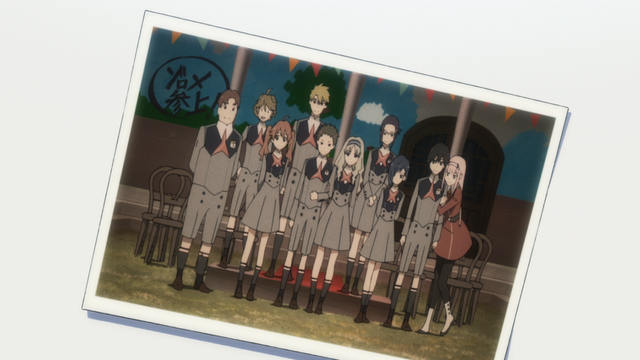 A group photo with 10 different characters standing in front of an illustrated wall and a set of chairs.