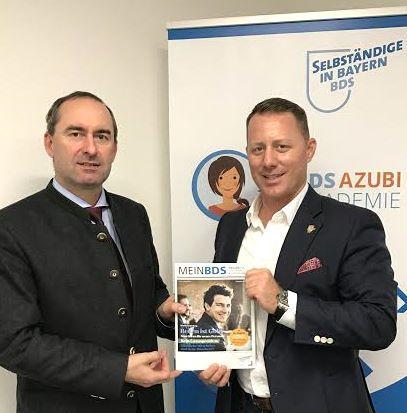 Marco Altinger nebst Hubert Aiwanger, gemeinsam halten sie eine Ausgabe des Magazins "MEIN BDS". BDS - Selbstständige in Bayern ist ein lokaler Unternehmerverband, dessen Vorsitz Marco Altinger (neben anderen) inne hatte. Mehrfach fiel der BDS durch politisch weit rechte Positionen auf. 