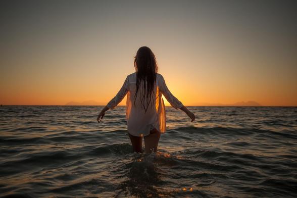 Mujer de espaldas entrando al mar.