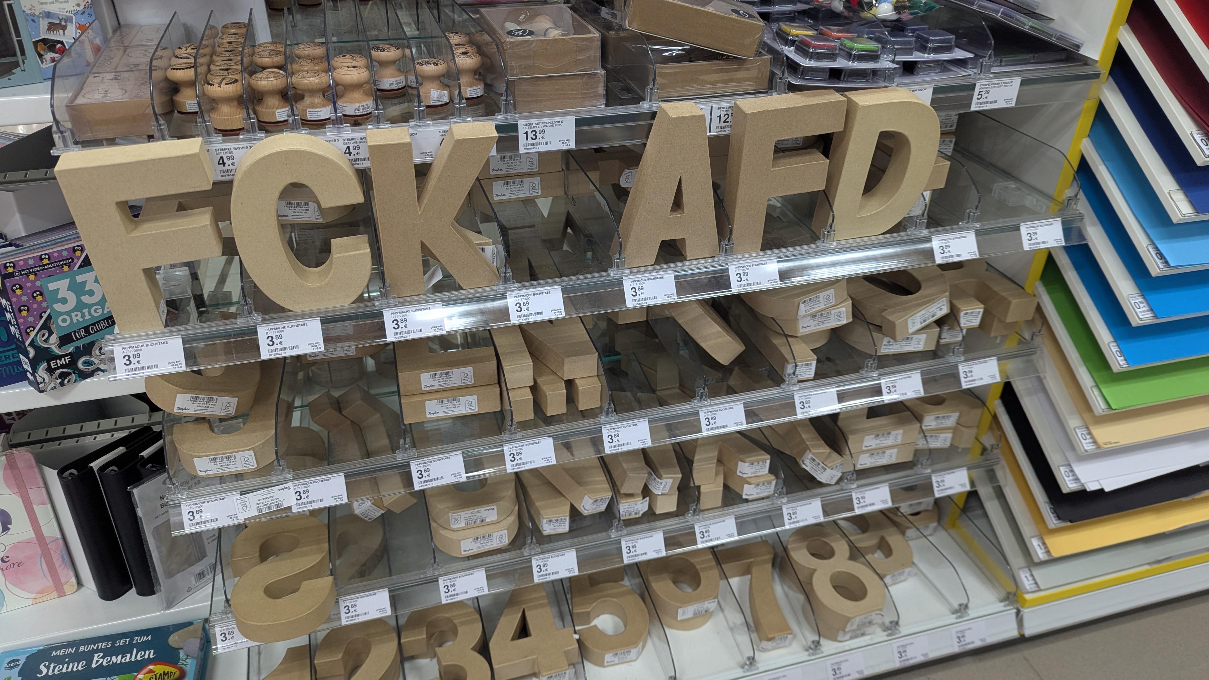 Regal im Müller-Markt mit Buchstaben aus Pappmaché die sortiert nach FCK AFD stehen.