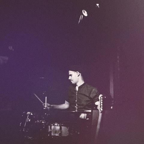 Ext Sleep playing in a dimly lit setting. Dark clothing, focused expression, atmospheric lighting creates a moody, artistic vibe.
