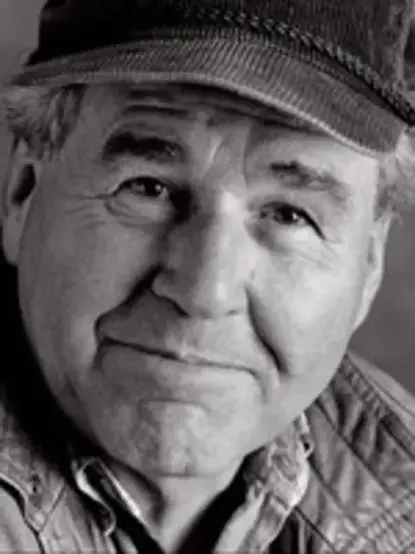 Photograph of an earnest looking middle-aged man wearing a billed cap