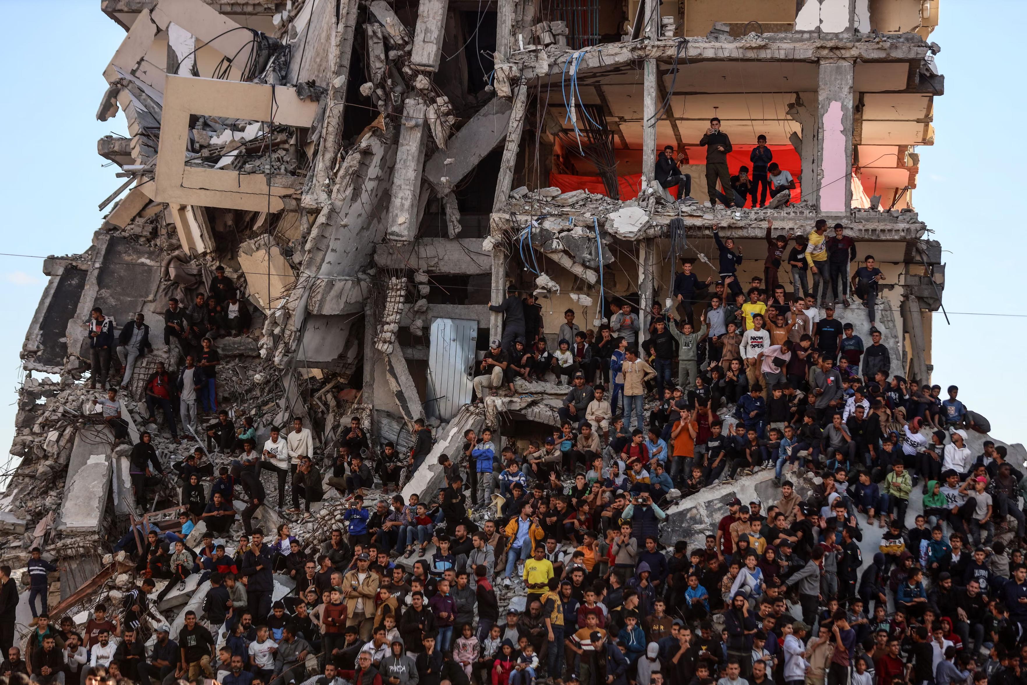 Family and friends try to get a good view among the rubble of damaged buildings.