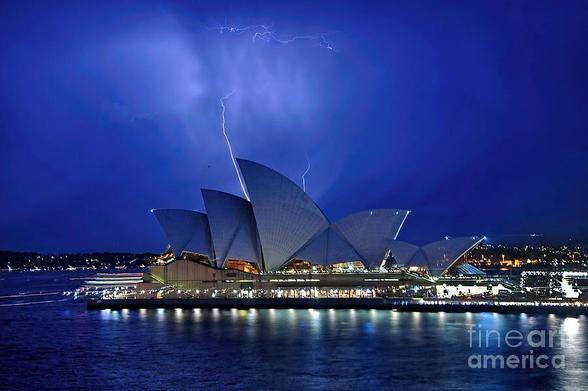 * ACHIEVED 1ST PLACE IN FAA CONTEST - Australian Extreme Weather - December 2025
* Equal 3rd place in FAA Contest - UNESCO World Heritage - June 2015.
* Equal 2nd place in FAA Harbour Bridge & Opera House Contest - June 2013.

One of my night captures of The Sydney Opera House on a hot balmy night in Sydney on 1st Dec. 2012... just as the lightning struck. The skies were magnificent and the storms were brewing.

The Sydney Opera House is a multi-venue performing arts center in Sydney, New South Wales, Australia.

The Sydney Opera House was made a UNESCO World Heritage Site on 28 June 2007. It is one of the 20th century's most distinctive buildings and one of the most famous performing arts centres in the world.

The Sydney Opera House is on Bennelong Point in Sydney Harbour, close to the Sydney Harbour Bridge. It sits at the north-eastern tip of the Sydney central business district (the CBD), surrounded on three sides by the harbour (Sydney Cove and Farm Cove) and inland by the Royal Botanic Gardens.

THE FINE ART AMERICA LOGO WILL NOT APPEAR ON PURCHASED PRINTS OR PRODUCTS.