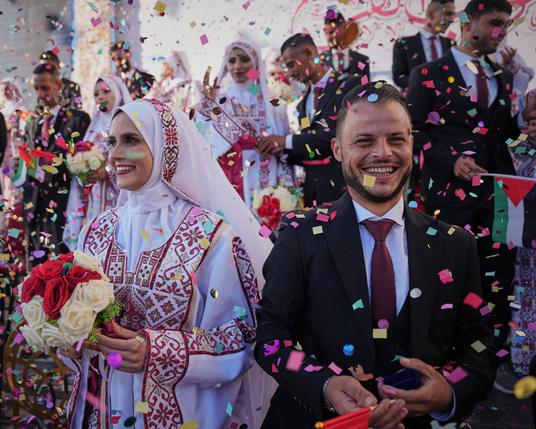 Palestinian couples take part in a mass wedding ceremony in Hamad City in Khan Younis, Gaza. Photograph: Abdel Kareem Hana/AP