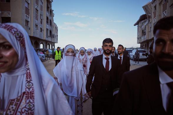 Palestinian couples get married in a mass wedding.