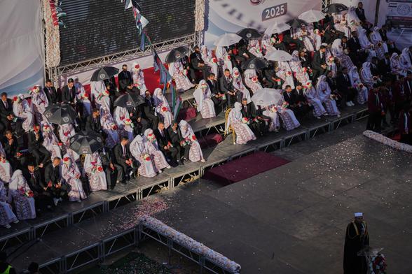 Women dressed in traditional Palestinian attire at their mass wedding ceremony.

