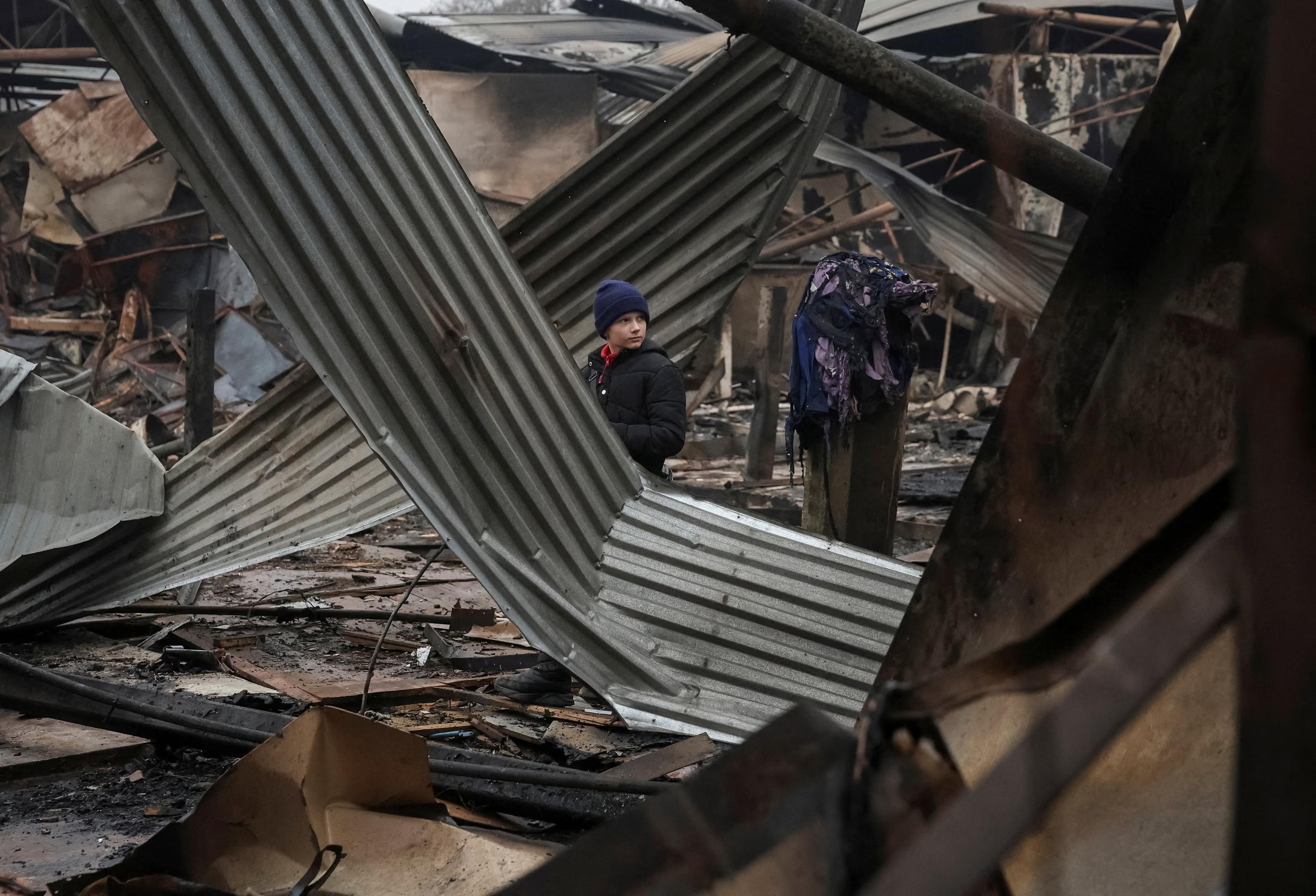 A boy looks at the damaged central market hit by a Russian strike.
