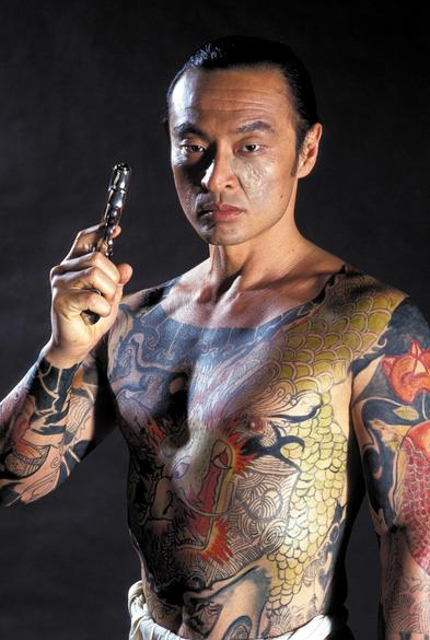 Japanese-born actor and film producer Cary-Hiroyuki Tagawa as leader of The Iron Claw gang, Funekei Yoshida in the 1991 American buddy cop action film “Showdown in Little Tokyo” . He’s shirtless and his upper body is covered in intricate tattoos. He’s wearing a traditional Japanese undergarment called a Fundoshi while brandishing a gun. 