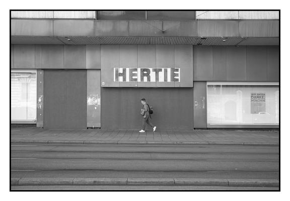Mann vor geschlossenem Eingang zu geschlossenem Kaufhaus. Über dem Eingang Schild "Hertie". Leere Schaufenster.
