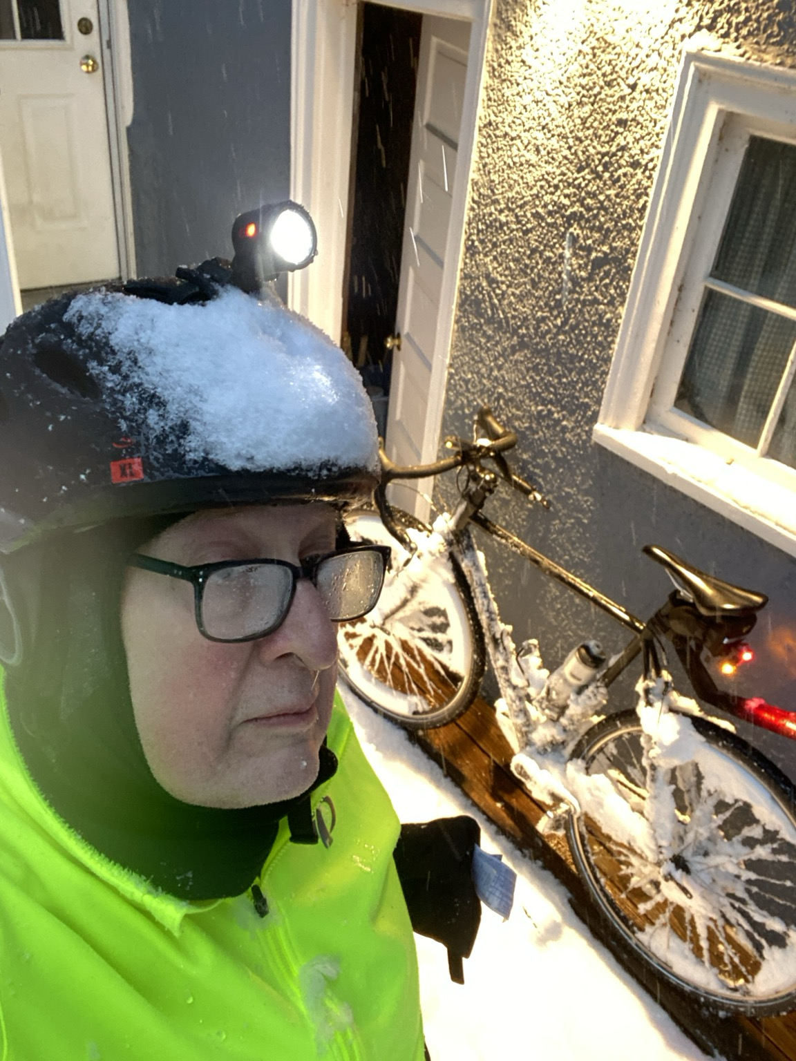 Selfie. Bike helmet covered in snow. Bike covered in snow.