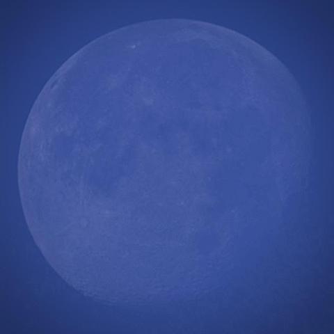 A picture of the moon during the day time. Everything is tinted blue, and details are harder to pick out due to a bit of light clouds/fog/haze. This image is stacked from a 30 second video on the Seestar S30. 