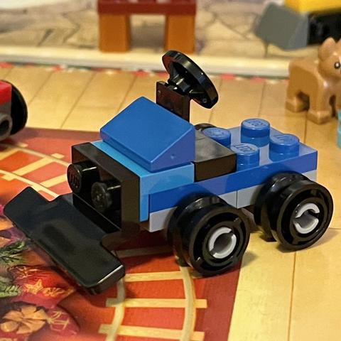 Miniature Lego snow plow. Blue with a black plow blade.