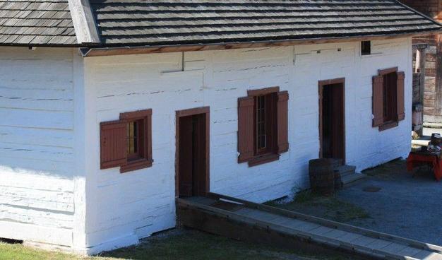 Historic post and sill house of the HBC trade, whitewashed and shingle roofed. This is the old storehouse at replica Fort Langley.