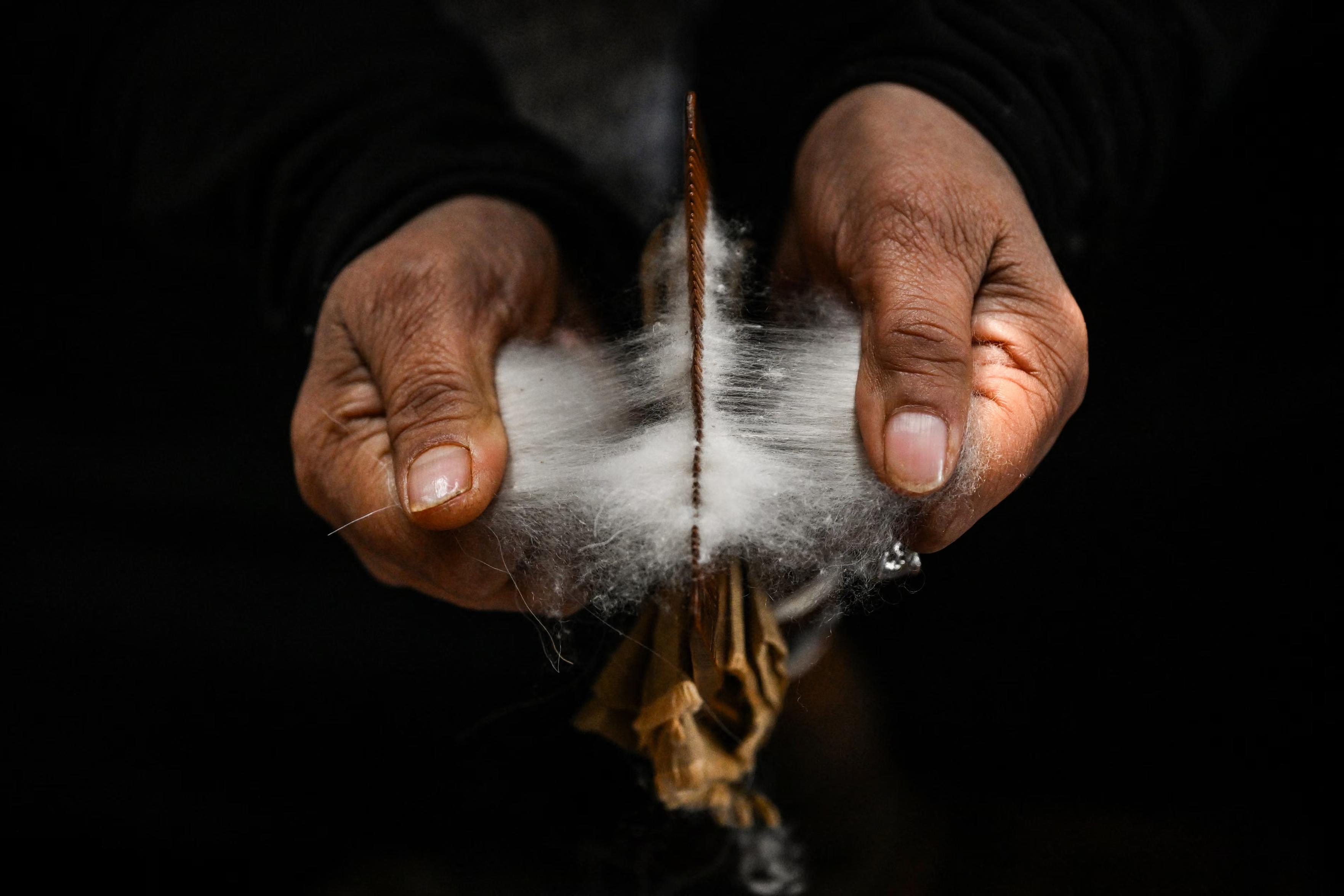 An artisan works on a Kashmiri pashmina shawl on a traditional handloom.