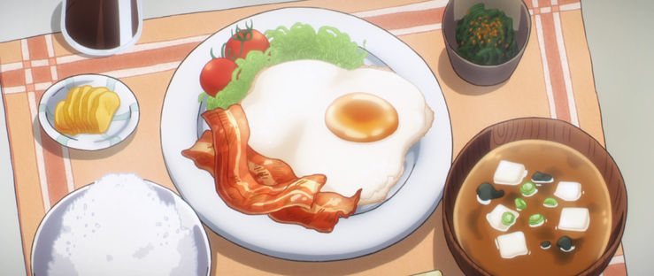 An array of plates and bowls with typical Japanese breakfast items.