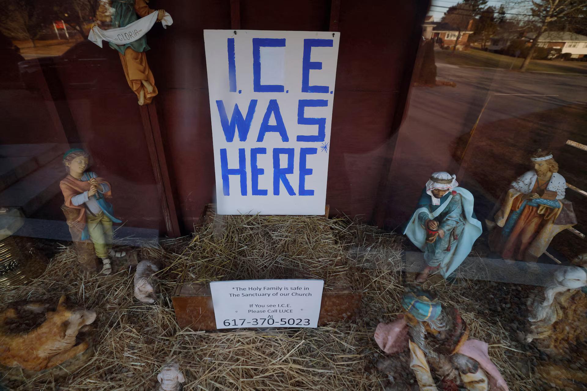 A sign reading "ICE Was Here" stands in the outdoor Nativity Scene, with the images of the Virgin Mary and St. Joseph missing.