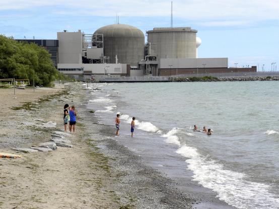 Menschen Baden am Strand "Frenchman's Bay (Pickering - Bay Ridges)", im Hintergrund ist das KKW Pickering zu sehen. Titel: "Fancy an atomic swim?"
Autor: JasonParis, https://www.flickr.com/people/94064020@N00
Lizenz: CC BY 2.0