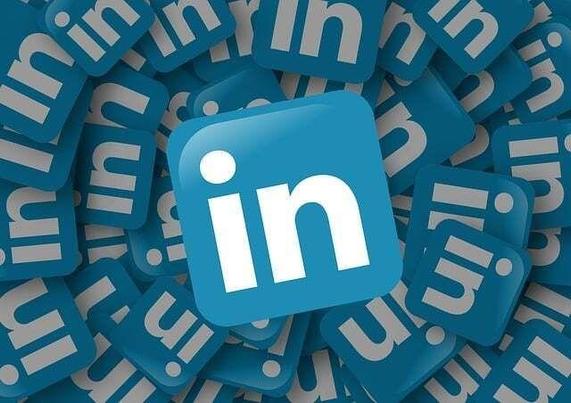 A blue and white linkedin logo atop a pile of linkedin logos.
