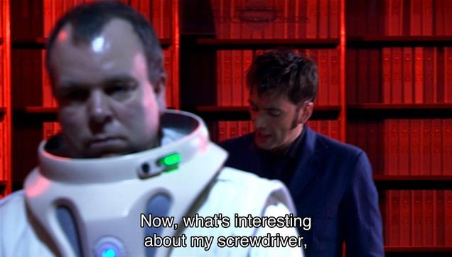 David Tennant episode. (Aren’t they all?) The Doctor is in a library, with demonic looking red lights shining down on the bookshelves and a bunch of miserable looking people standing around in space suits without helmets, so really, without the books, it wouldn’t look very much like a library at all. The Doctor is running around as he’s talking, because that’s generally who he is, so he’s a bit out of focus in all these images. Caption reads, “Now, what's interesting about my screwdriver, very hard to interfere with. Practically nothing's strong enough. Well, some hair dryers, but I'm working on that.”