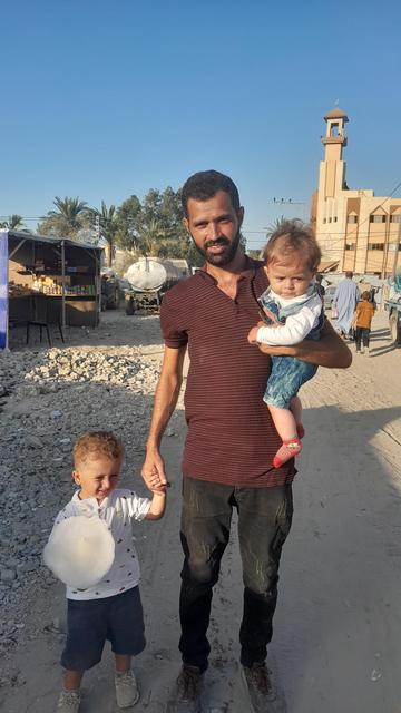 A picture of Salem. He is holding hands with his older little boy and is carrying the younger baby boy on his left hip. Salem has a nicely trimmed mustache and beard. His hair is dark and he has dark eyes. The children's clothes are clean, but Salem's are a little dusty. Salem is also underweight in this picture, while the children seem a bit healthier because has been putting his familyâs needs before his own, so he hasn't had as much to eat. He is a very good father. đ
Salem and his wife dream of a better life, where Salem can realize his dream of healing children, his wife may exercise her creative talents, & their children may have safe, warm beds to sleep in at night.
Please help in any way you can. Every life is so precious.