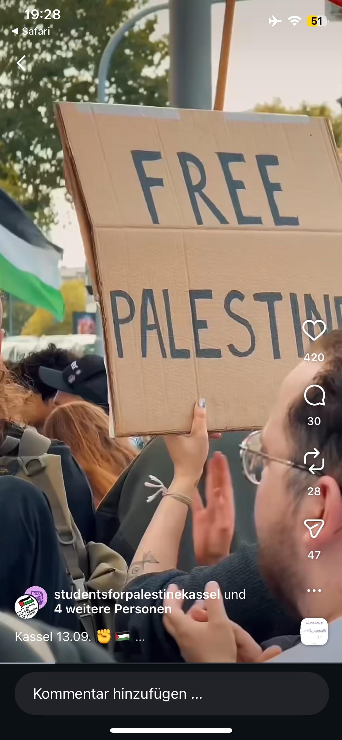 Eine Person hält während einer Demonstration ein Pappschild mit der Aufschrift "FREIES PALÄSTINA". 