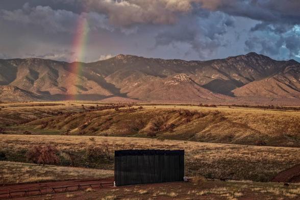 A drone view shows a new section of the border wall that stands in Arizona's San Rafael Valley with rainbow up.