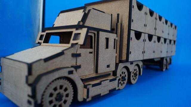 Schräge Perspektive auf Truck und Anhänger, deutlich sichtbar: gelaserte Linien, viele kleine Steckverbindungen und Räder mit Zahnraddesign.