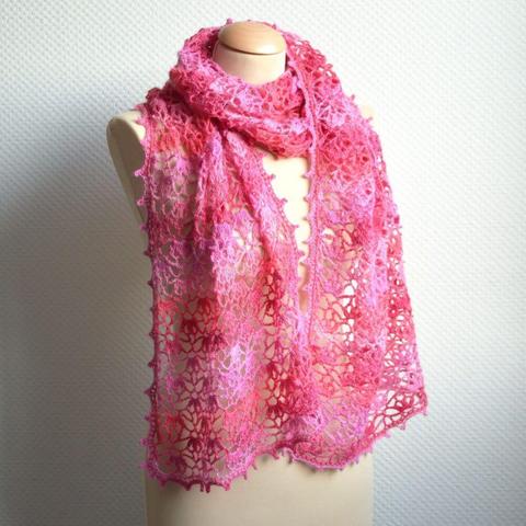 A lace crochet stole in a pink variegated yarn, shown from the front on a mannequin against a white background.
