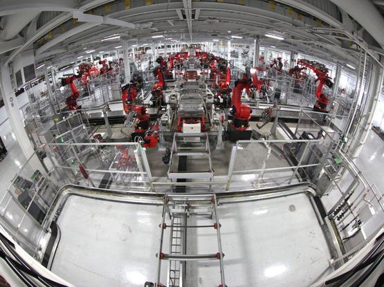 The end of decent paid jobs and the need for basic income: a fisheye view photograph of a production line of industrial robots devoid of humans. Photo attribution: Flickr user&nbsp;jurvetson.