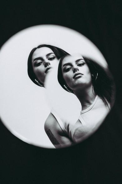 Mujer reflejada en dos espejos.