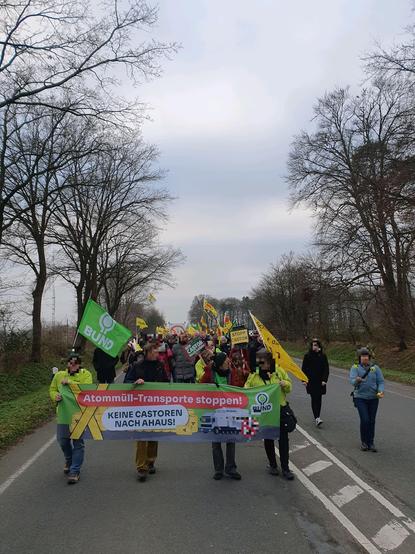 Demozug auf dem Weg zum Seiteneingangstor des Atommüll-Zwischenlager Ahaus, auf dem Frontbanner vom BUND (Bund für Umwelt und Naturschutz Deutschland) der Spruch: "Atommüll-Transporte stoppen! Keine Castoren nach Ahaus!".