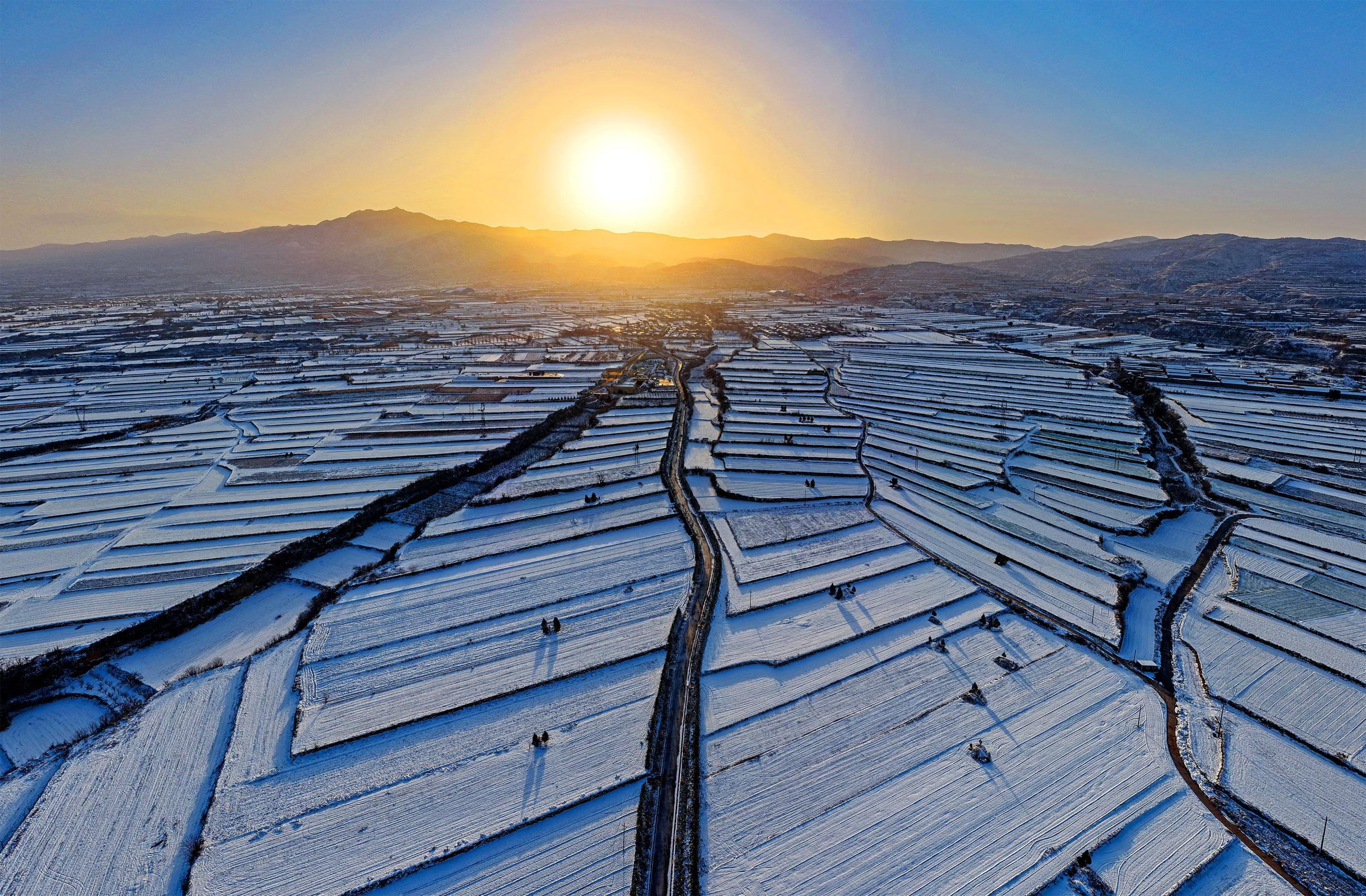 An aerial drone photo shows a view of the snow-covered terraces at sunrise.
