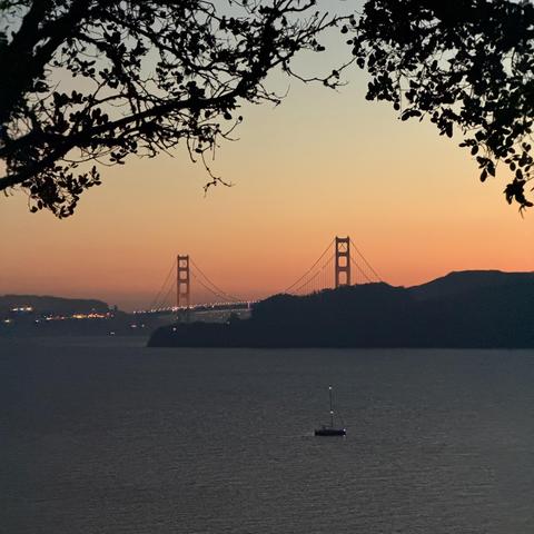 Evening photograph of the Golden Gate Bridge with golden sunset behind