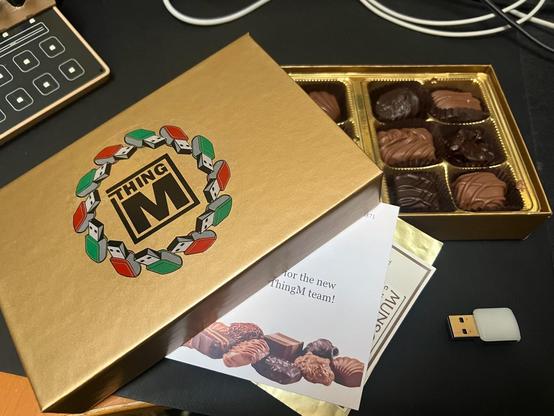chocolate box with the ThingM logo surrounded by a wreath made from stylized blink(1) USB LED devices