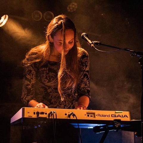 Woman playing a synthesizer on stage